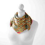 Colorful patterned scarf on a mannequin against a white background