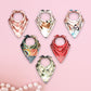 Set of colorful bandana-style scarves on a pink background