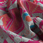 Close-up of a vibrant pink fabric with intricate patterns and designs.