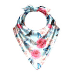 Floral and butterfly patterned baby bib on a white background