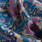 Close-up of colorful fabric with intricate patterns in blue, pink, and white.