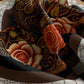 Decorative fabric with intricate patterns and colors, featuring fish and floral designs.