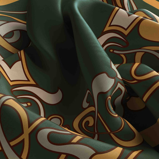 Close-up of patterned fabric with green, gold, and brown colors.