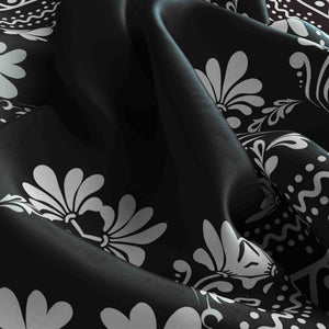 Black fabric with white floral patterns on a black background