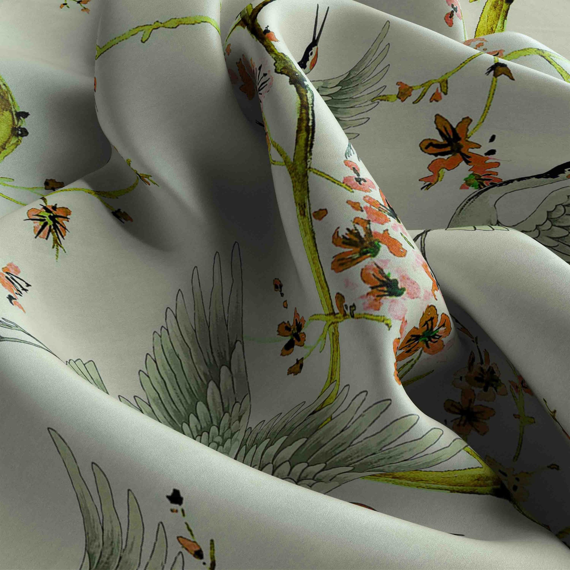 Floral and bird patterned fabric with green, orange, and black colors on a white background.