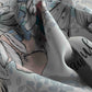 Close-up of a person's leg with tattoos on a patterned background