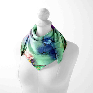 Colorful floral scarf on a mannequin against a white background