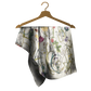Floral-patterned scarf on a wooden hanger against a white background