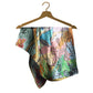 Colorful patterned fabric on a wooden hanger against a white background
