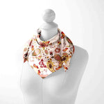 Decorative scarf with floral and paisley pattern on a mannequin against a white background