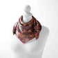 Colorful paisley patterned scarf on a mannequin against a white background